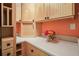 Well-lit laundry room with a light countertop, blonde wood cabinets, and decorative flowers at 1507 Country Park Se Dr, Smyrna, GA 30080