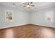 Bright bedroom featuring hardwood floors, a ceiling fan, and two large windows at 4010 Arborwood Ln, Tucker, GA 30084