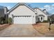 Home exterior featuring a two-car garage, well-maintained lawn, and nicely landscaped front yard at 4010 Arborwood Ln, Tucker, GA 30084