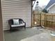 Cozy patio area with a wicker bench, neutral cushion, decorative pillow, and access to a fenced yard at 4010 Arborwood Ln, Tucker, GA 30084