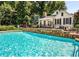 Inviting pool with stone accents, perfect for relaxation and recreation next to a charming white home with dark shutters at 50 Sycamore Sta, Decatur, GA 30030