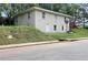 Two-story home on a sloped lot featuring neutral siding, simple landscaping, and convenient street access at 5125 West St, Forest Park, GA 30297