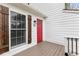 Close up of the front entry showing a red door with sidelight and window with dark shutters at 712 Berts Nw Cir, Lilburn, GA 30047