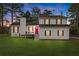 Charming two-story home features a red front door, green lawn, and traditional shutters at 712 Berts Nw Cir, Lilburn, GA 30047