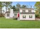 Charming two-story home features a red front door, green lawn, and traditional shutters at 712 Berts Nw Cir, Lilburn, GA 30047