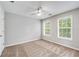 Bedroom features neutral walls, carpet, two windows, and a ceiling fan at 980 Charter Club Dr, Lawrenceville, GA 30043