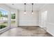 Dining area featuring large windows that flood the room with natural light, complemented by elegant pendant lights at 980 Charter Club Dr, Lawrenceville, GA 30043