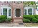 Welcoming front entrance with brick steps, lush landscaping, and a stylish front door at 980 Charter Club Dr, Lawrenceville, GA 30043