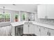 Bright kitchen with quartz countertops, stainless steel dishwasher, and a view to the outdoor deck at 980 Charter Club Dr, Lawrenceville, GA 30043