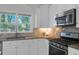Kitchen featuring stainless steel appliances, granite countertops, and white cabinets at 1464 Sagamore Ne Dr, Atlanta, GA 30345