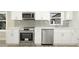A modern kitchen showcases stainless steel appliances, white cabinets, and a tile backsplash at 4585 Yates Rd, Atlanta, GA 30337
