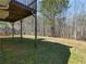 A view from under the deck of the spacious backyard shows a wooden fence and the wooded area beyond at 195 Brighton Dr, Covington, GA 30016