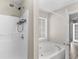 Modern bathroom featuring a large bathtub with jets, shower, and a bright window at 195 Brighton Dr, Covington, GA 30016