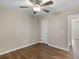 Neutral bedroom featuring wood-look floors, a ceiling fan, and a bright white door at 195 Brighton Dr, Covington, GA 30016