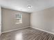 This bedroom features a window for natural lighting, hardwood floors, and neutral-colored walls at 195 Brighton Dr, Covington, GA 30016