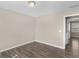 This bedroom features hardwood floors, neutral-colored walls, and opens to another room at 195 Brighton Dr, Covington, GA 30016