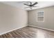 Comfortable bedroom with hardwood floors, ceiling fan, and a window bringing in natural light at 195 Brighton Dr, Covington, GA 30016