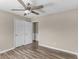 This bedroom features two closets, hardwood floors, a ceiling fan, and neutral-colored walls at 195 Brighton Dr, Covington, GA 30016