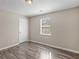 This bedroom features a window for natural lighting, hardwood floors, and neutral-colored walls at 195 Brighton Dr, Covington, GA 30016