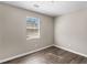 Cozy bedroom offers wood-look floors, a window, and neutral paint at 195 Brighton Dr, Covington, GA 30016