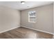 This bedroom features a window for natural lighting, hardwood floors, and neutral-colored walls at 195 Brighton Dr, Covington, GA 30016