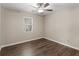 Comfortable bedroom featuring ceiling fan, wood-look floors, and natural light from the window at 195 Brighton Dr, Covington, GA 30016