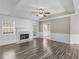 Bright living room featuring wood floors, fireplace, tray ceiling, and a door leading to the deck at 195 Brighton Dr, Covington, GA 30016