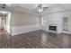 Bright living room featuring wood floors, fireplace, tray ceiling, and a doorway leading to another room at 195 Brighton Dr, Covington, GA 30016