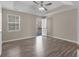 Bright primary bedroom with tray ceiling, ceiling fan, hardwood floors, and access to a private deck at 195 Brighton Dr, Covington, GA 30016