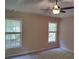 Bedroom featuring neutral walls, carpet, ceiling fan and two windows letting in plenty of natural light at 2015 Aldbury Ln, Woodstock, GA 30189