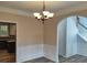 Dining room with wainscoting, chandelier, arched doorway, and luxury vinyl flooring at 2015 Aldbury Ln, Woodstock, GA 30189