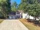 Two-story home features a two-car garage, complemented by a well-kept lawn and trees at 2015 Aldbury Ln, Woodstock, GA 30189