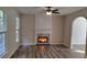 Bright living room featuring a fireplace, an archway, and modern vinyl flooring at 2015 Aldbury Ln, Woodstock, GA 30189