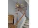 Staircase with wooden handrail, white banisters, modern lighting fixture, and neutral wall color at 2015 Aldbury Ln, Woodstock, GA 30189