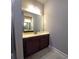 Bathroom featuring a single sink vanity with cabinets, large mirror, and tiled floor at 42 Champions Crossing, Villa Rica, GA 30180