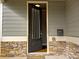 Close-up of the front door with stone accent wall, with convenient mailbox and doorbell at 42 Champions Crossing, Villa Rica, GA 30180