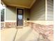 View of the covered front porch with stone base columns and accent wall at 42 Champions Crossing, Villa Rica, GA 30180