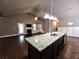 Open-concept kitchen with granite island, dark cabinets, and view into the living area at 42 Champions Crossing, Villa Rica, GA 30180