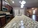 Spacious kitchen featuring a granite island, stainless steel appliances, and dark wood cabinets at 42 Champions Crossing, Villa Rica, GA 30180