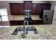 Close up of a kitchen island with stainless steel sink and granite countertop at 42 Champions Crossing, Villa Rica, GA 30180