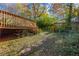 Wooden deck overlooking the backyard, framed by lush greenery and stone path, creating a serene outdoor space at 15 Corinth Rd, Cartersville, GA 30121