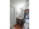 A well-lit bathroom with a brown vanity, neutral countertop, and a stacked cabinet with towels and toilet paper at 15 Corinth Rd, Cartersville, GA 30121