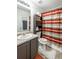 Bright bathroom featuring a single sink vanity, grey countertop, cabinet for towels, and a stylish striped shower curtain at 15 Corinth Rd, Cartersville, GA 30121