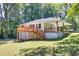 Rear view of home with a deck, lawn and partial basement entrance at 1875 Creekside Ct, Decatur, GA 30032