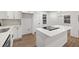 Bright, white kitchen featuring stainless steel appliances, stone countertops, and a breakfast bar with a modern cooktop at 1875 Creekside Ct, Decatur, GA 30032