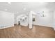 Open-concept living room featuring wood flooring, modern lighting, white walls, and a view of the kitchen and breakfast bar at 1875 Creekside Ct, Decatur, GA 30032