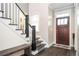 Warm foyer with hardwood floors, a staircase, a bench, and a wooden front door at 2541 Kickerillo Se Way, Atlanta, GA 30316