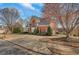 Side view of a brick house featuring a well-maintained lawn and driveway, nestled among mature trees at 4753 Outlook Ne Way, Marietta, GA 30066