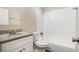 Well-lit bathroom featuring a granite countertop, white cabinets, and a shower-tub combo at 6510 Connell Rd, Atlanta, GA 30349