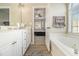 Bathroom featuring a soaking tub and dual sink vanity; view into the main bedroom at 113 Glenmore Ln, Mcdonough, GA 30253